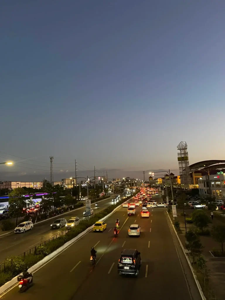 Evening view of city traffic with cars and motorcycles on a busy road