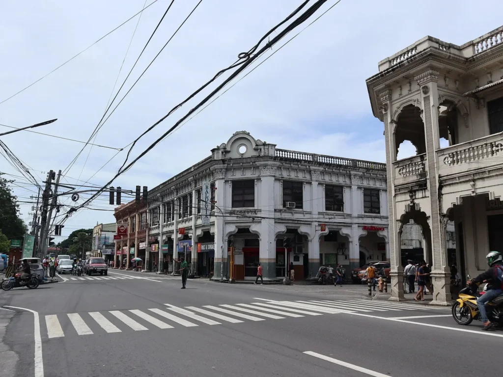A bustling city street featuring historical architecture and modern establishments.